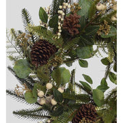 Karácsonyi koszorú, fenyőágakból és eukaliptuszokból, fenyőtobozokkal és fehér erdei bogyókkal díszítve.