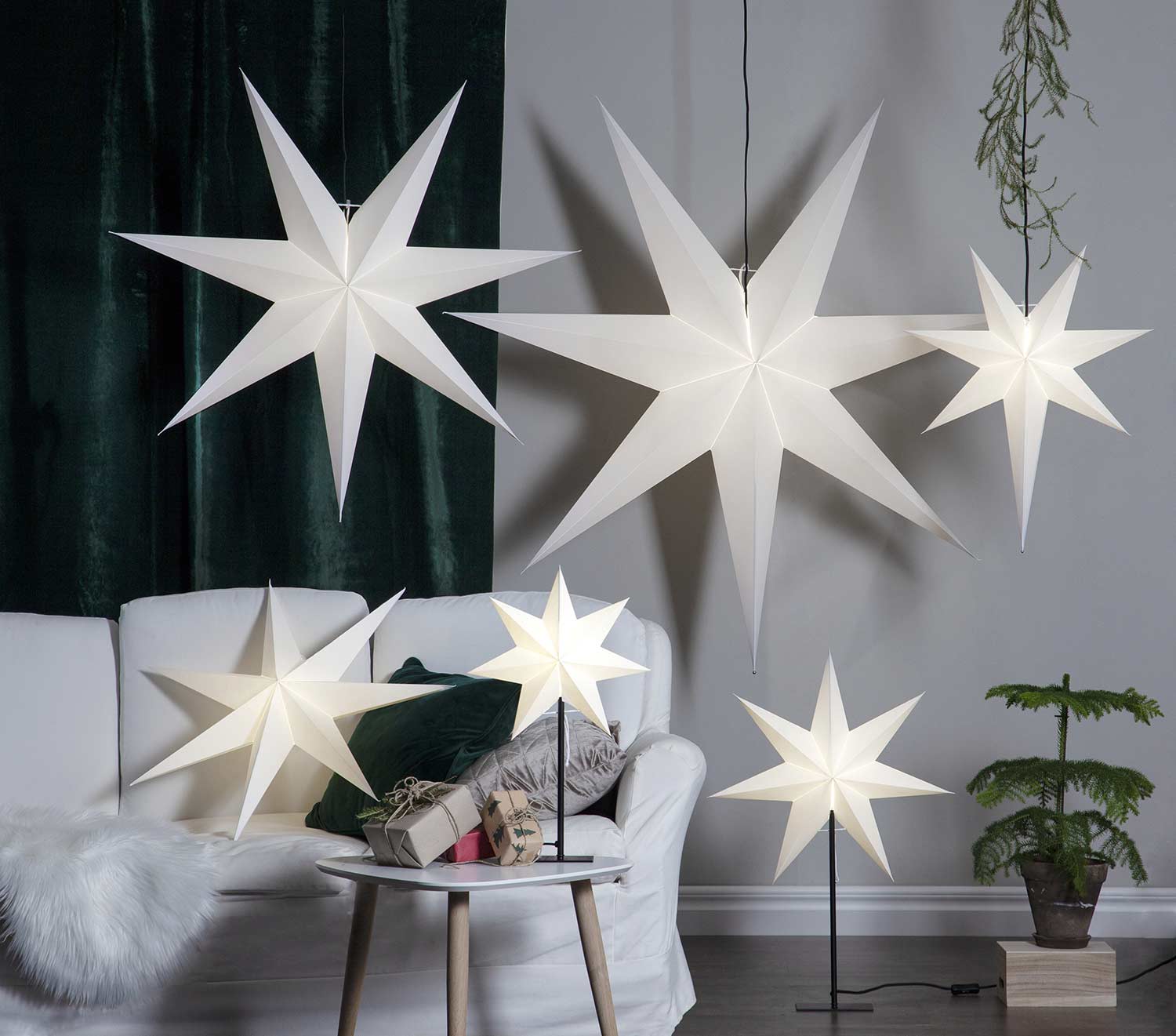Többféle méretű és formájú, fehérszínű, világító karácsonyi papírcsillagok,