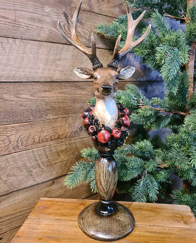 Vintage stílus, csipkebogyó koszorúval díszített, dekoratív karácsonyi szarvas mellszobor, fenyőfával.