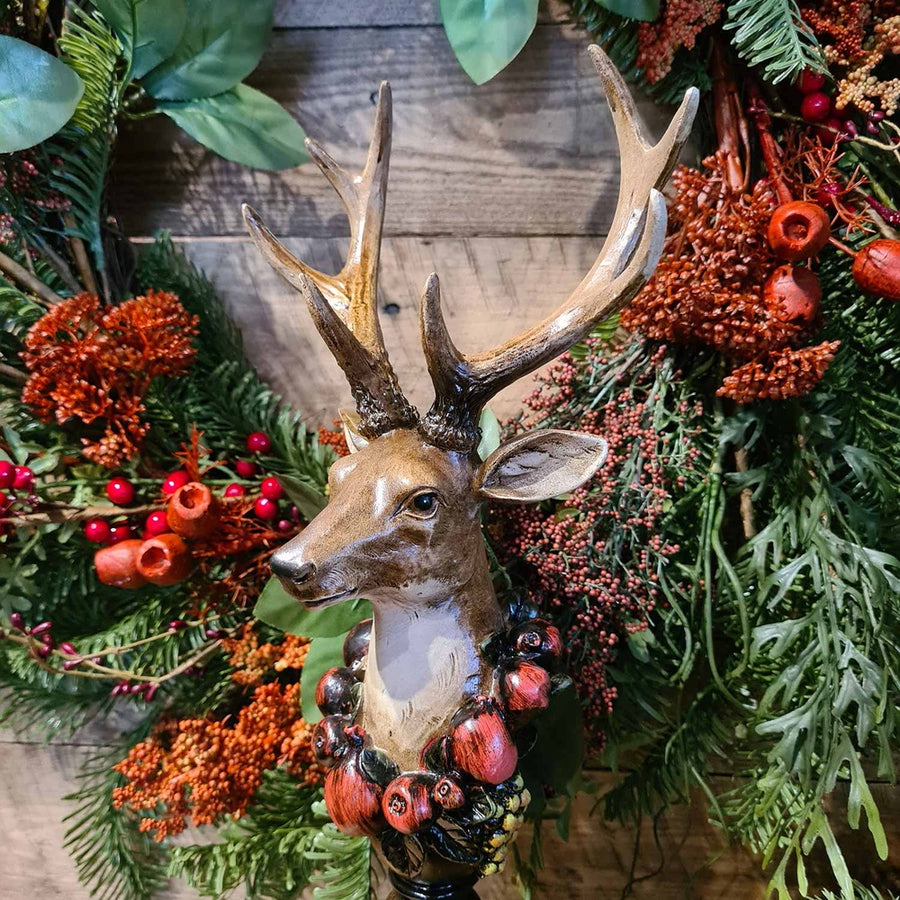Vintage stílus, csipkebogyó koszorúval díszített, dekoratív karácsonyi szarvas mellszobor, erdei koszorúval.