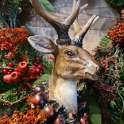 Vintage stílus, csipkebogyó koszorúval díszített, dekoratív karácsonyi szarvas mellszobor, erdei koszorúval.