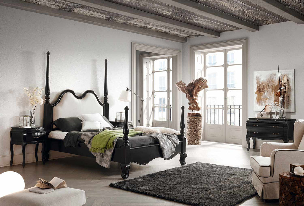 Fekete színű, mahagónifából készült franciaágy deszkamennyezetes szobában.