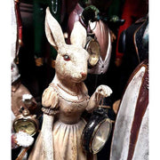 Női nyuszifigura szoknyában, kezében órát és esernyőt tart