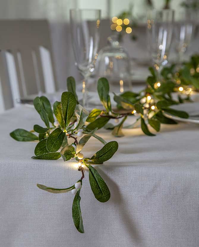 LED-es fagyöngy girland karácsonyi ünnepi asztalon.