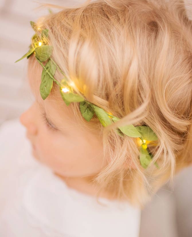 Mesterséges, 95 cm hosszú apró, zöld levelű girland műnövény, meleg fehér fényű, harmatcsepp formájú LED világítással kislány hajában