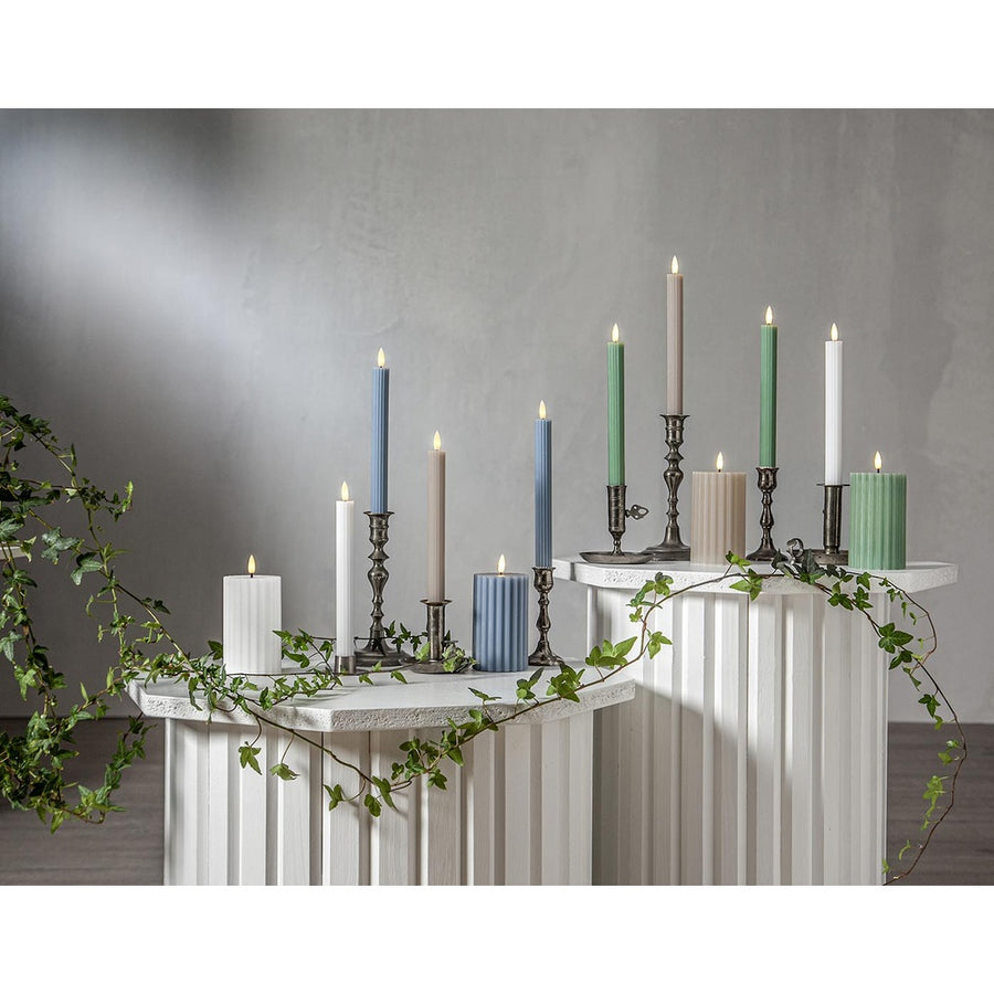Stripe LED gyertya kollekció különböző méretű és színű valódi viaszból készült kannelúrás gyertyákkal, vintage gyertyatartókban elhelyezve, meleg fényű LED lánggal.