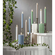 Stripe LED gyertya kollekció különböző méretű és színű valódi viaszból készült kannelúrás gyertyákkal, vintage gyertyatartókban elhelyezve, meleg fényű LED lánggal.