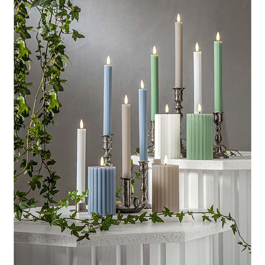 Stripe LED gyertya kollekció különböző méretű és színű valódi viaszból készült kannelúrás gyertyákkal, vintage gyertyatartókban elhelyezve, meleg fényű LED lánggal.
