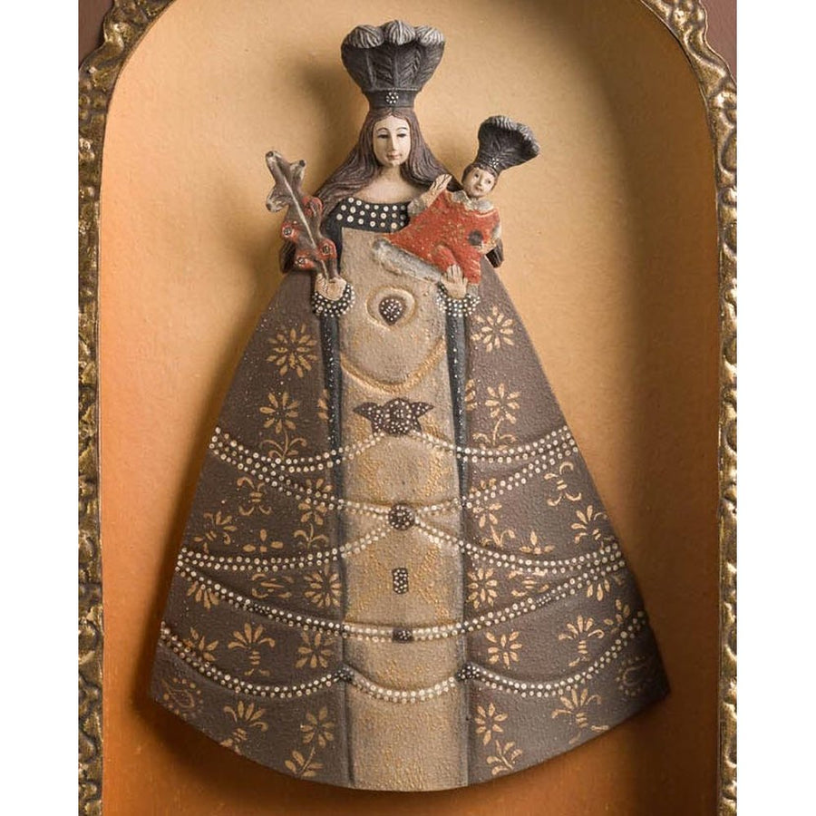 Szoborfülkés fa képkeretbe foglalt, a Liliomos Madonnát ábrázoló figura.