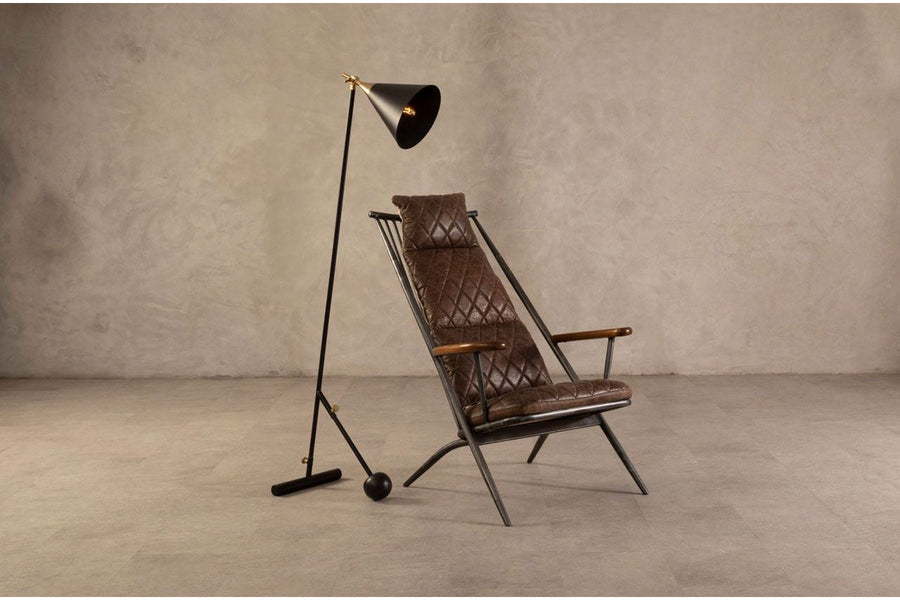 Vasból készült, vintage sötétbarna színű marhabőrrel kárpitozott, kortárs-loft stílusú, formatervezett prémium pihenő karosszék, állólámpával modern bemutatóteremben.