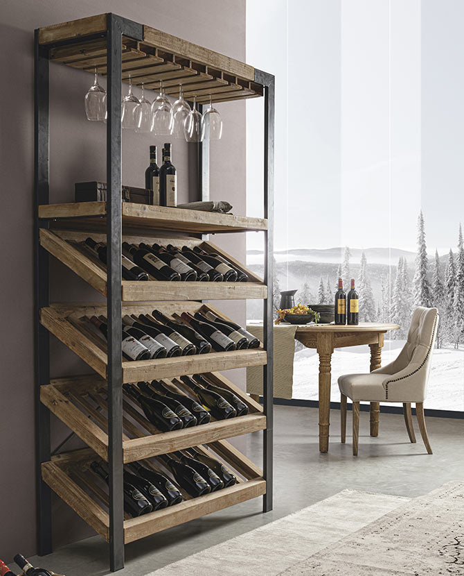 Loft stílusú bortartó polcos állvány, szürke fal előtt, megrakva borospalackokkal és poharakkal.