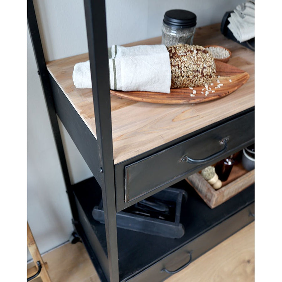 Loft, ipari stílusú, kerekekkel felszerelt, antik fekete színű, fém fiókos polcos állvány  fenyő polca, rajta magvas kenyér 