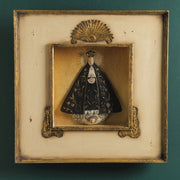 Szoborfülkés fa képkeretbe foglalt, a Magányos Szűzanyát ábrázoló figura.