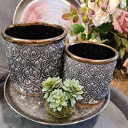 Közelkép a szürke Dalia kaspó mintázatáról arany peremmel és dekorációval