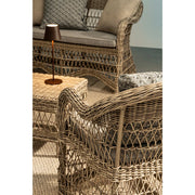 Vidéki vintage stílusú, natúr színű műrattan kerti fotel, bézs színű olefin ülőpárnával.