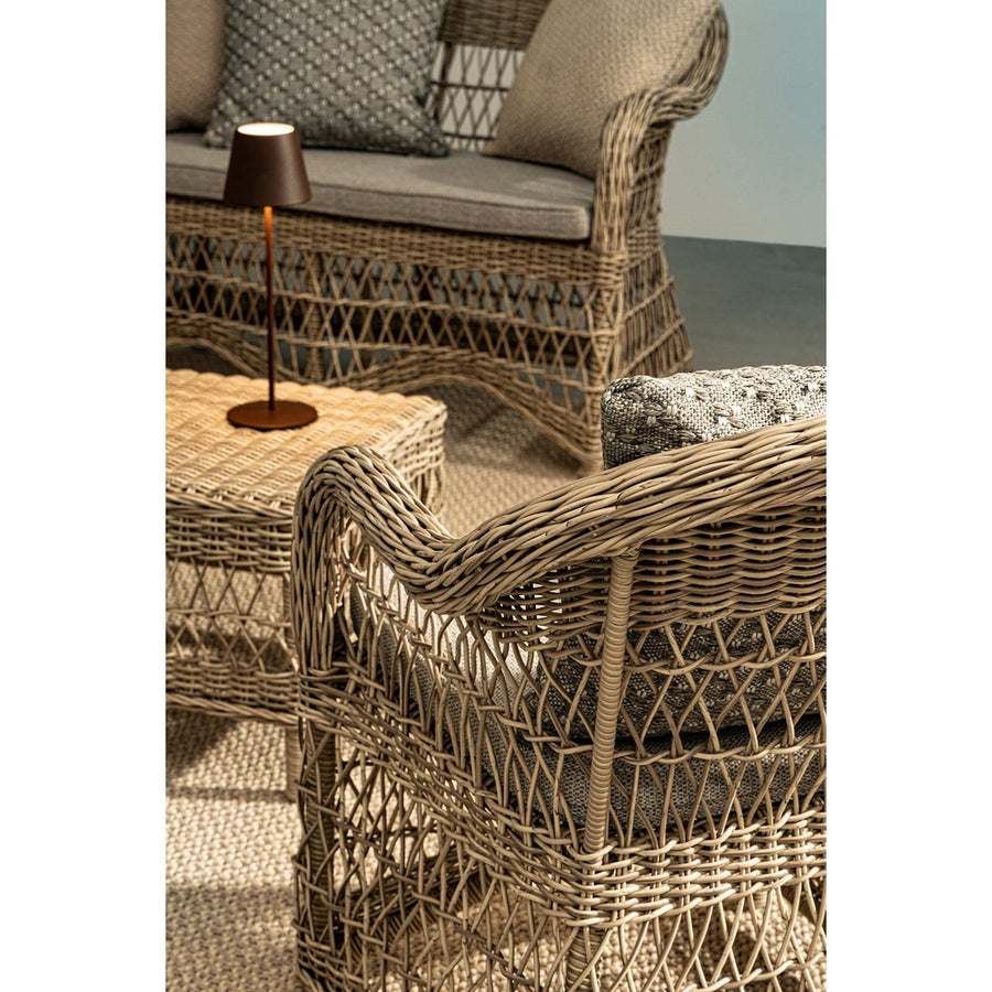 Vidéki vintage stílusú, natúr színű műrattan kerti fotel, bézs színű olefin ülőpárnával.