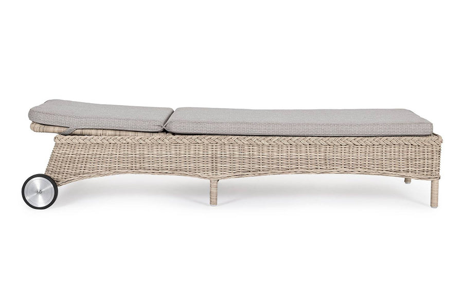 Vidéki vintage stílusú, kerekekkel felszerelt,, dönthető háttámlájú, natúr színű műrattan napozóágy, bézs színű olefin fekvőpárnával,