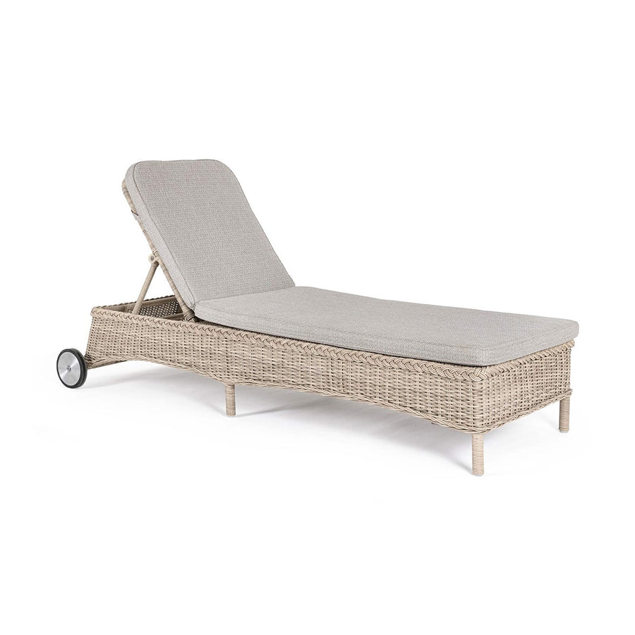 Vidéki vintage stílusú, kerekekkel felszerelt,, dönthető háttámlájú, natúr színű műrattan napozóágy, bézs színű olefin fekvőpárnával,