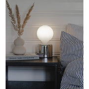 Ezüst színű, modern asztali lámpa, matt felületű, opál LED izzóval éjjeliszekrényen. 