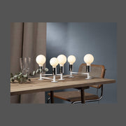 Matt felületű opál LED izzók modern asztali lámpában, fa asztalon.