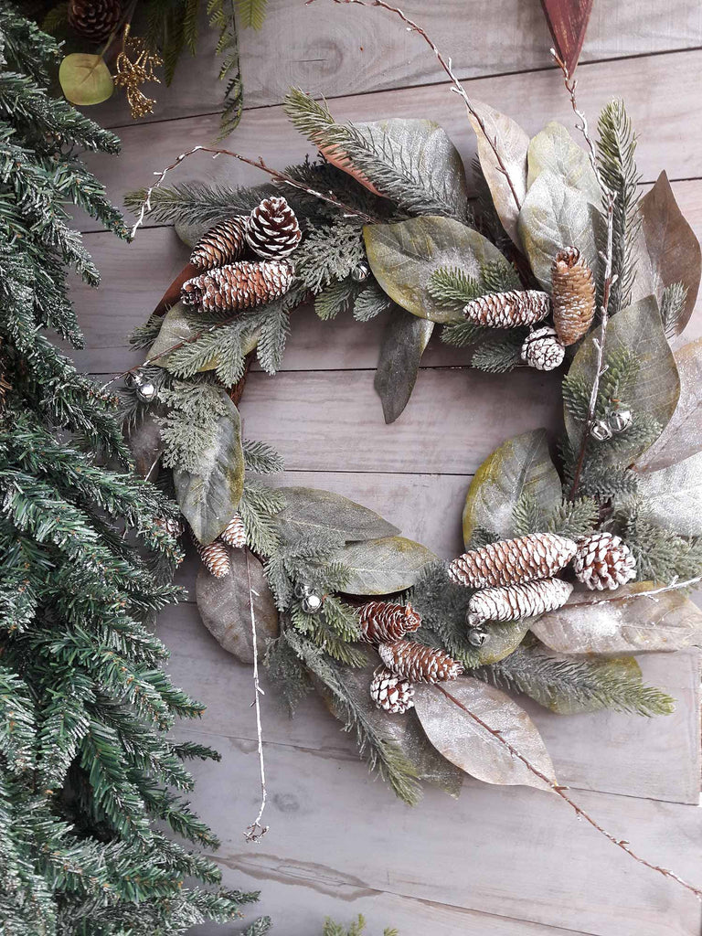 Karácsonyi deres felületű babérkoszorú, szürke színű deszkafalon.