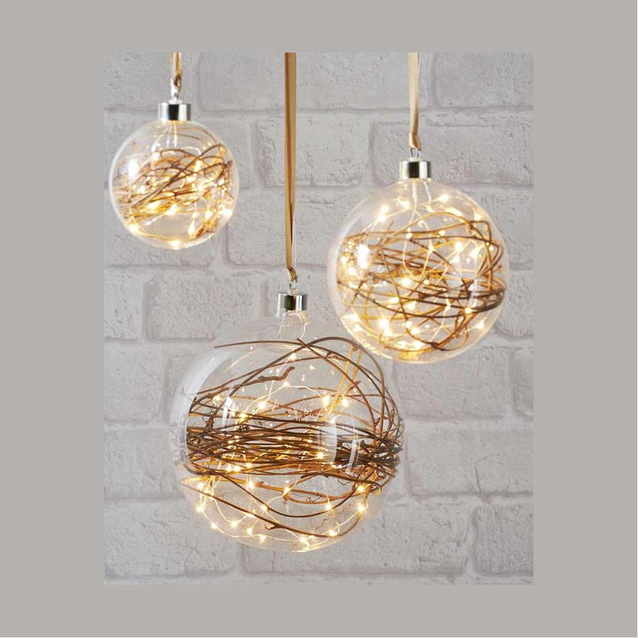 Áttetsző, nagyméretű, karácsonyi üveggömb, 40 darab LED égővel és gallyal a belsejében.