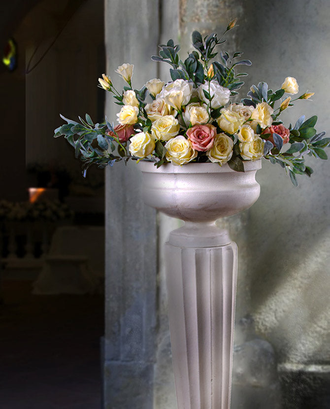 Óriás méretű, sima felületű, fehér színű talpas kaspó kannelúrás posztamensen  virágokkal 