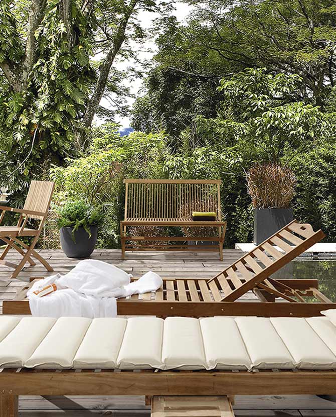 Prémium minőségű, 100 cm hosszú, mediterrán stílusú, összecsukható kézműves kerti teakfa pad napozóágyakkal egy dzsungelben 