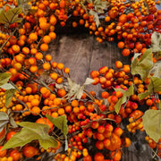 Őszi hangulatú mű koszorú sárguló levelekkel és bogyókkal, bejárati ajtó dekorációhoz.