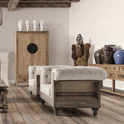 Prémium kategóriás, gyarmati stílusú, újrahasznosított trópusi fából készült, tört fehér színű szövettel kárpitozott fotelek vidéki stílusú nappaliban, deszka padlón , gerendás mennyezettel 