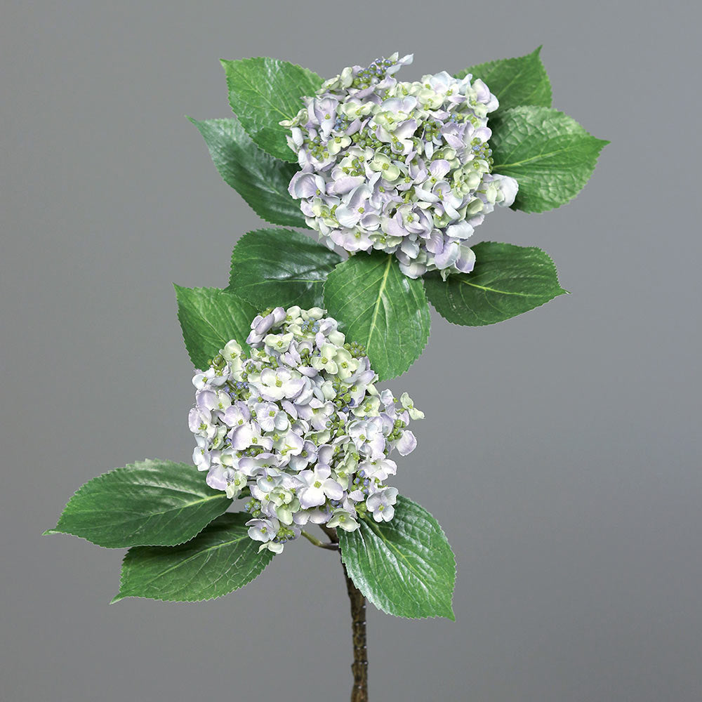 Halványlila színárnyalatú virágfejjel díszített mű hortenzia ág.