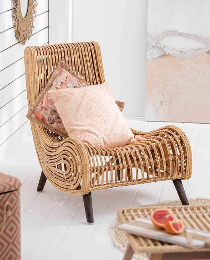 Natúr színű rattan pihenő fotel bézs párnákkal, világos nappaliban. 