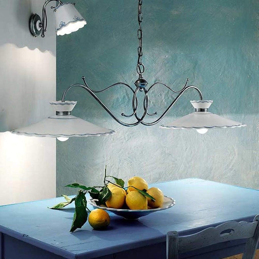 Kerámiából és fémből készült, textilburkolatú vezetékkel kialakított, kézműves függeszték lámpa, citromos kék asztal fölött.