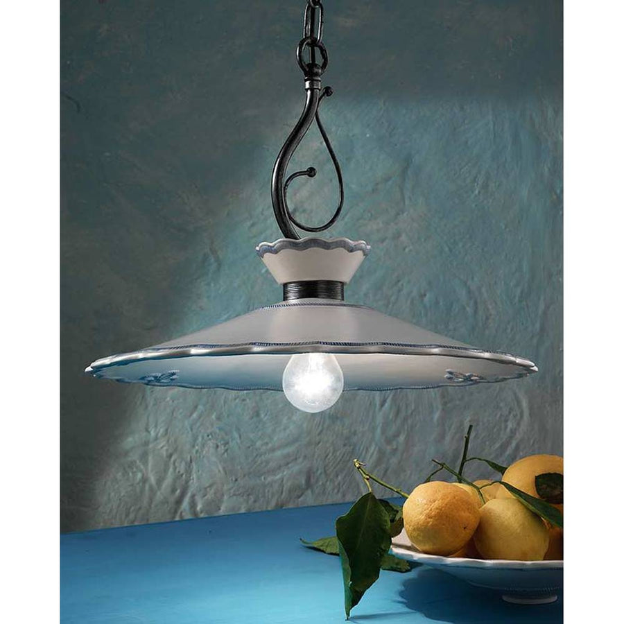 Kerámiából és fémből készült, textilburkolatú vezetékkel kialakított, kézműves függeszték lámpa, citromos kék asztal fölött.