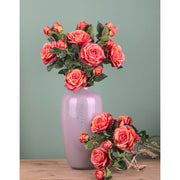 Rózsa művirág, narancsos pink színárnyalatú nyílt és bimbós virágfejekkel.