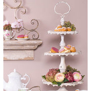 Shabby Chic stílusú, 3 szintes, antikolt fehér színű, fém süteményes kínáló jól  megpakolva aprósüteményekkel, és virágokkal.