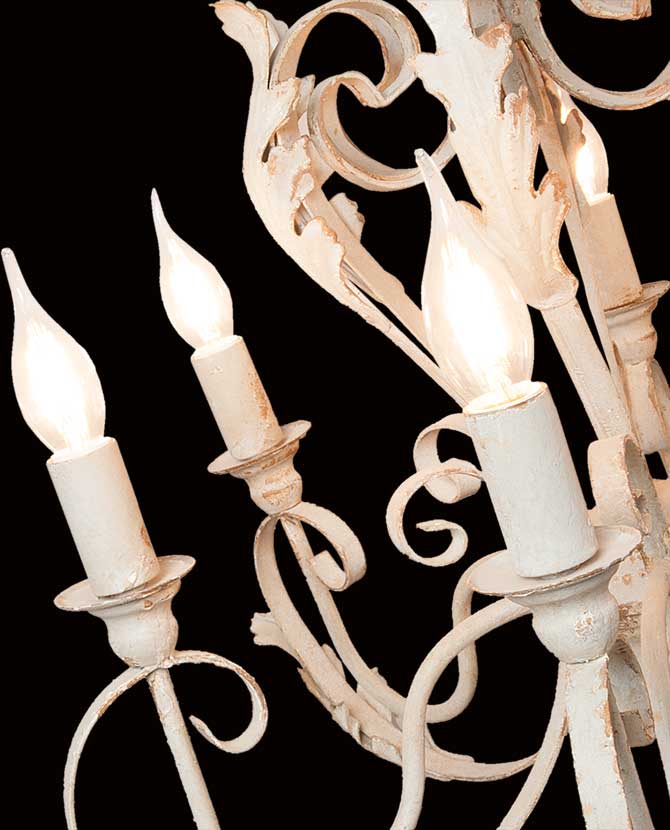 Shabby Chic stílusú, krém színű, antikolt felületű, fém akantuszlevelekkel díszített, 6 karú "Antoinette" fém csillár lámpakarjainak közeli képe, világító izzókkal, fekete háttér előtt