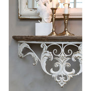 Antikolt patinás felületű konzolos fali polc réz színű gyertyatartókkal.