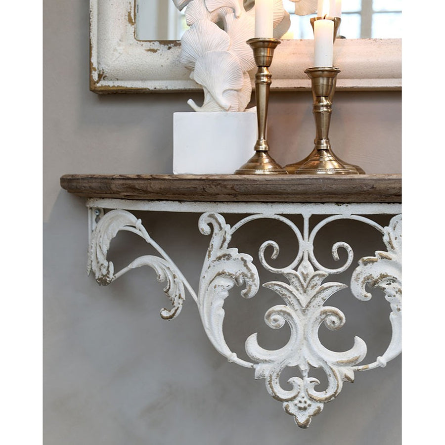 Antikolt patinás felületű konzolos fali polc réz színű gyertyatartókkal.