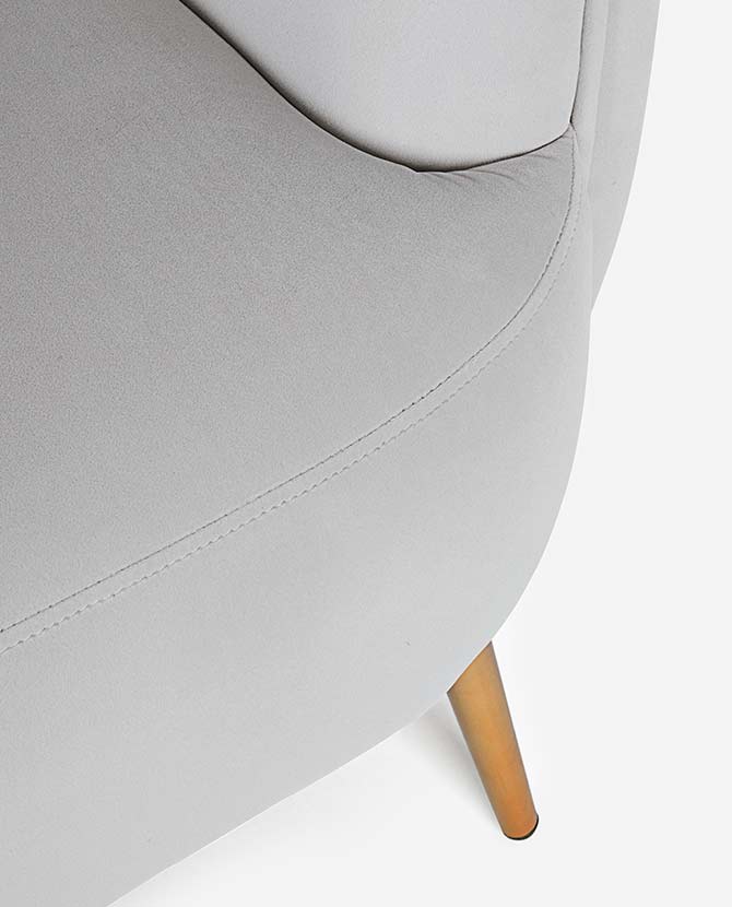 Skandináv stílusú, halványszürke színű bársonnyal kárpitozott fotel, arany színű fém lábakkal. ülés részlete.