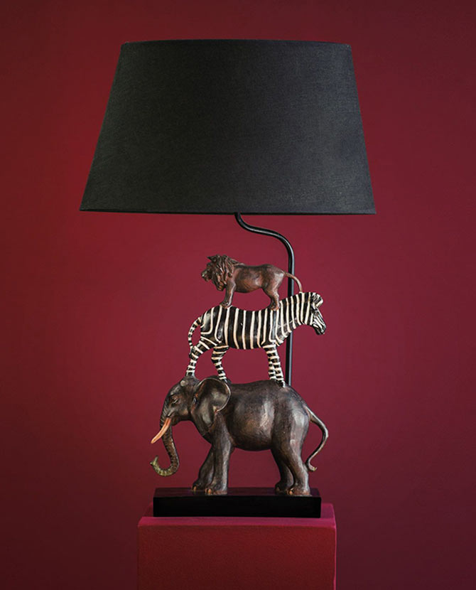 Szavannai állat figurás, 60 cm magas, trópusi stílusú asztali lámpa, bordó háttér előtt.