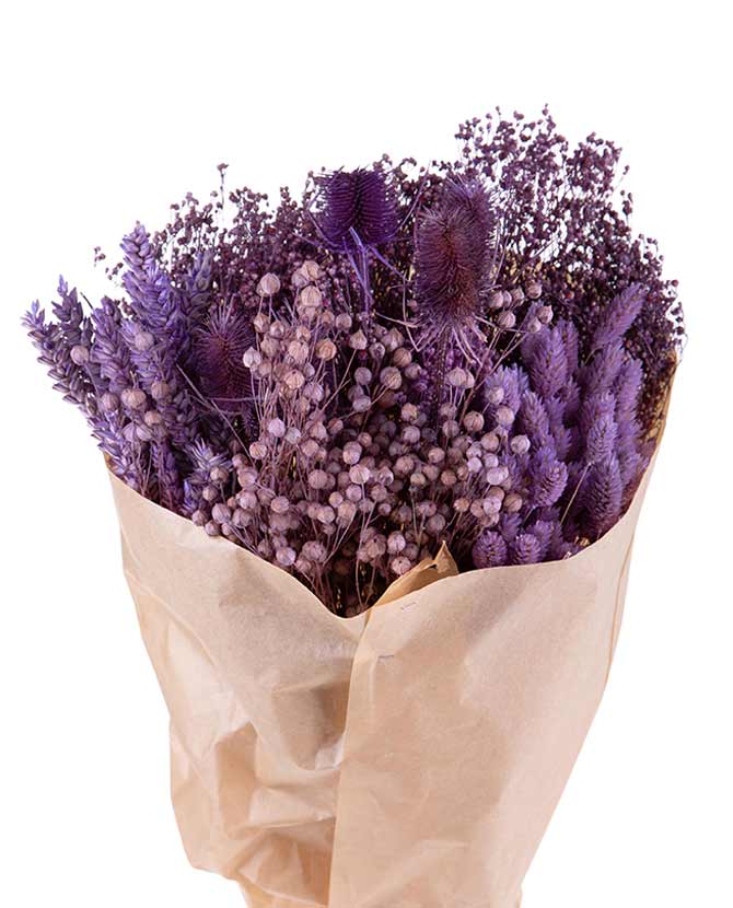 Natúr színű papírba csomagolt, 30 cm átmérőjű és 50 cm magas, vegyes kialakítású lila színű szárított gyógynövénycsokor