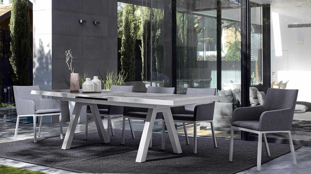 Modern kortárs stílusú, szürke színű, időjárás álló szövettel kárpitozott kerti karosszék modern teraszon asztallal. 