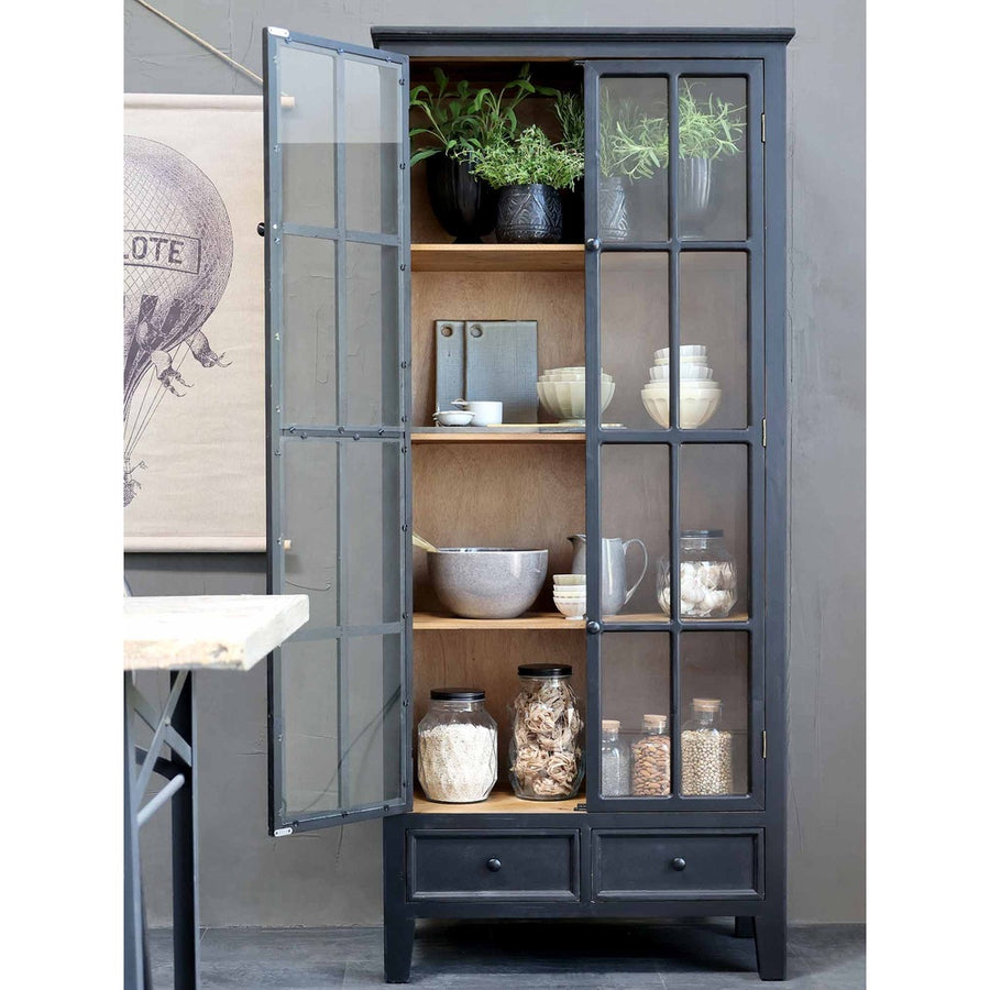 Fenyőfából készült,, rusztikus antikolt felületű, fekete színű, vintage stílusú, 2 fiókos vitrines szekrény nyitott ajtóval, polcain konyhai eszközökkel. 