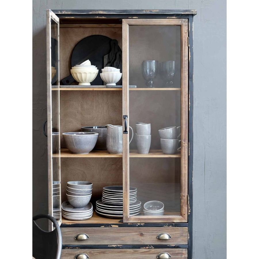 Vintage stílusú vitrin nyitott ajtaja, polcain porcelán konyhai étkészlet. 