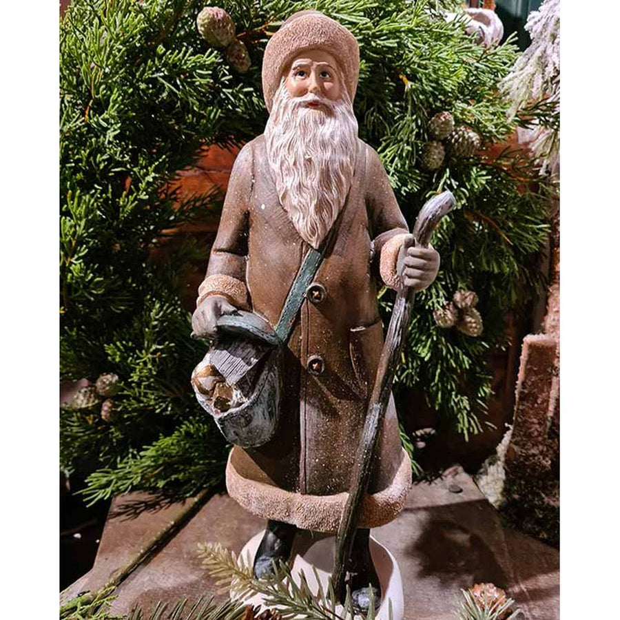 Prémium minőségű, vintage stílusú, 30 cm magas, barna színű, klasszikus Télapó figura zöld fenyőkoszorú előtt