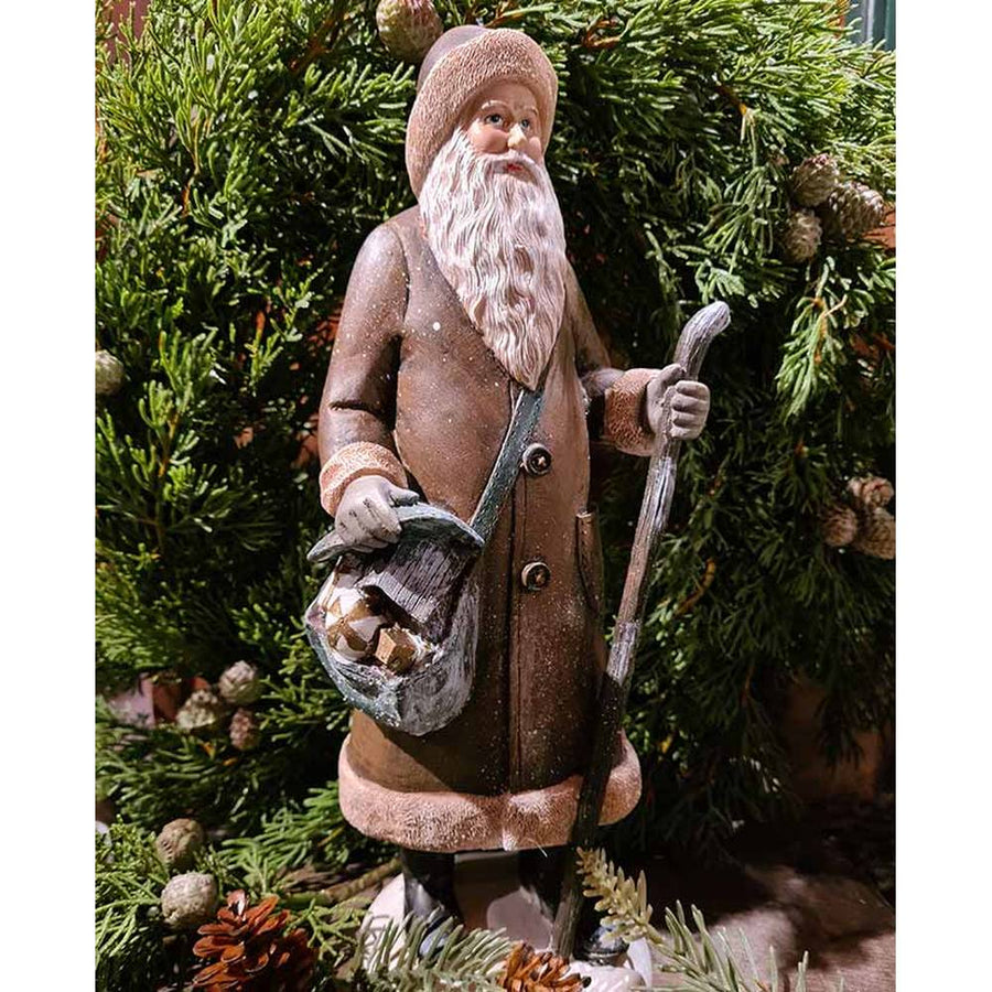 Prémium minőségű, vintage stílusú, 30 cm magas, barna színű, klasszikus Télapó figura zöld fenyőkoszorú előtt