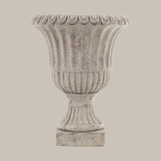 Antikolt felületű, szürke színű talpas cement kaspó.