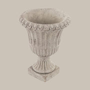 Antikolt felületű, szürke színű talpas cement kaspó.