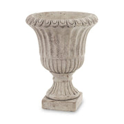 Antikolt felületű, szürke színű talpas cement kaspó.